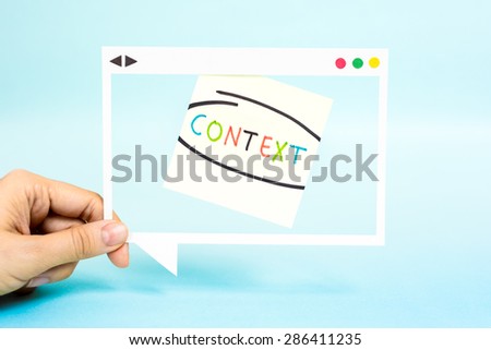 Hand holding speech bubble with the word Context. 