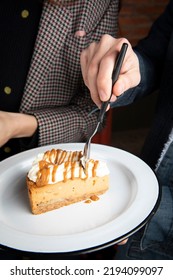 Hand Holding A Spoon Cutting A Piece Of Cake With Dulce De Leche