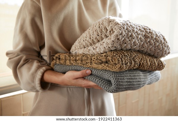 Hand holding a stack of sustainable\
cloths in tracksuit, homemade and Eco friendly\
fabric