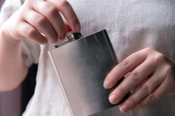 Hand Holding A Stainless Steel Hip Flask For Liquor, Alcohol And Drink Concept Close-up Luxe