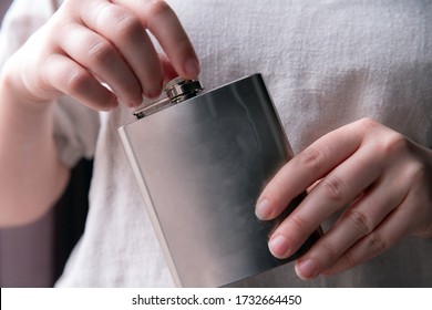 Hand Holding A Stainless Steel Hip Flask For Liquor, Alcohol And Drink Concept Close-up Luxe