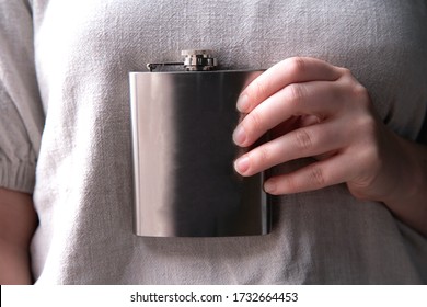 Hand Holding A Stainless Steel Hip Flask For Liquor, Alcohol And Drink Concept Close-up Luxe