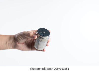 Hand holding stainless steel spice jar or dredge shaker on white background - Powered by Shutterstock