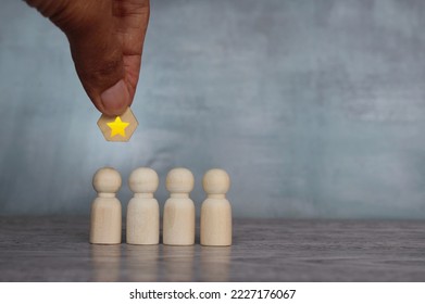 Hand holding a star over the team. Awarding, appreciation and reward for employees concept - Shutterstock ID 2227176067