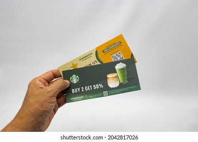 Hand Holding Starbucks Cafe 50% Discount Voucher. Jakarta 17 September 2021.