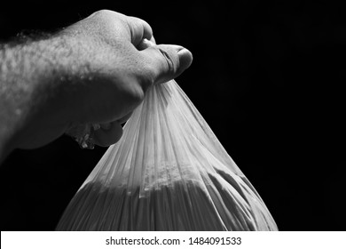 A Hand Holding A Stash Of Heroin. Drug Bust Concept Image. 