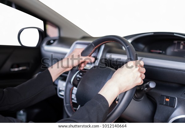 Hand holding steering wheel in modern private\
car with blank white\
windshield