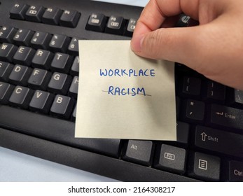 A Hand Holding A Sticky Note Showing The Words Workplace Racism 