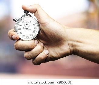 hand holding stopwatch against a abstract background