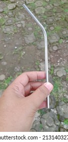 Hand Holding A Straw From Stainless Stee