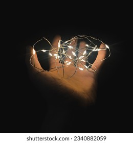 Hand holding string lights closeup