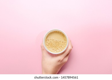 Hand Holding A Styrofoam Cup Of Hot Coffee Over The Pink Table Background