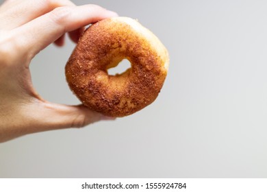 Hand Holding A Sugar Cinnamon Doughnut.