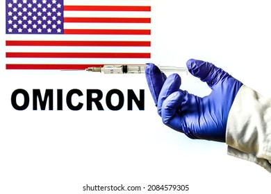 Hand Holding Syringe With Covid Vaccine. United States Flag And Omicron Covid Variant Word Written In The Background