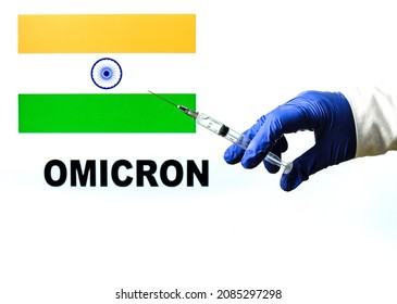 Hand Holding Syringe With Covid Vaccine. Indian Flag And Omicron Covid Variant Word Written In The Background