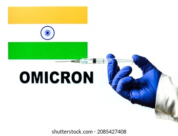 Hand Holding Syringe With Covid Vaccine. Indian Flag And Omicron Covid Variant Word Written In The Background