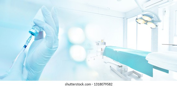 Hand holding syringe and medicine vial prepare for injection in operating room background with blue tone - Powered by Shutterstock
