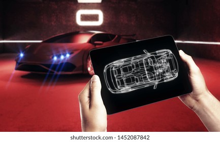 Hand Holding Tablet With Car Outline In Blurry Garage With Red Sportscar. Transport Diagnostics And Innovation Concept