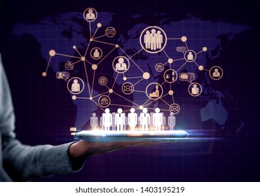 Hand holding tablet with glowing social network map on dark background. Global and HR concept - Powered by Shutterstock