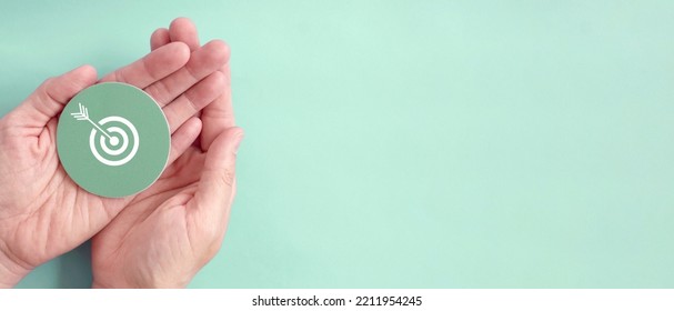 Hand holding target paper cut, achieve on point, sustianable challenge goal, business objective plan concept - Shutterstock ID 2211954245