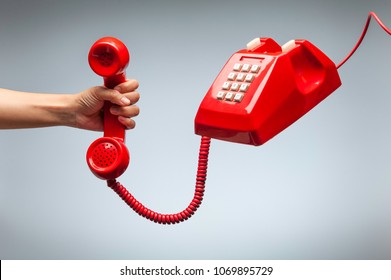 Hand Holding Telephone, Classic Red Telephone Receiver, Old Telephone Isolated On White Background Flying In Weightlessness.