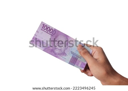 Hand holding ten thousand rupiah note isolated on white background