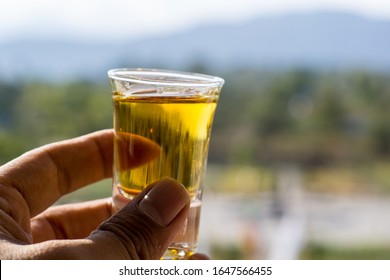 Hand Holding Tequila Shot Glass