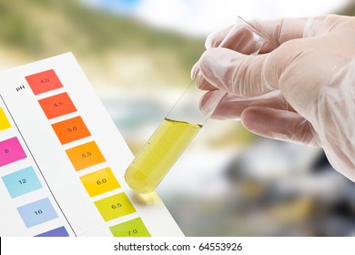 Hand Holding Test Tube With PH Indicator Comparing Color To Scale