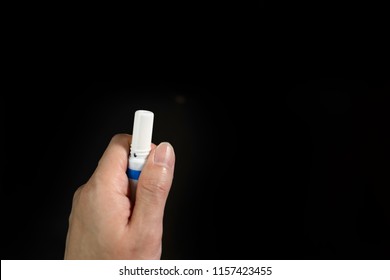 hand holding thai medical inhalant smelling salt isolated on black