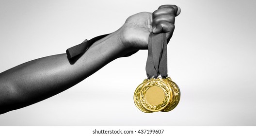 Hand Holding Three Gold Medals On White Background