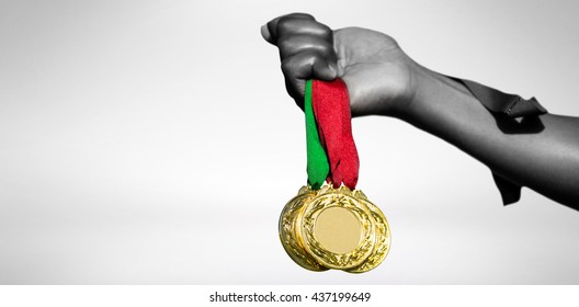 Hand Holding Three Gold Medals On White Background