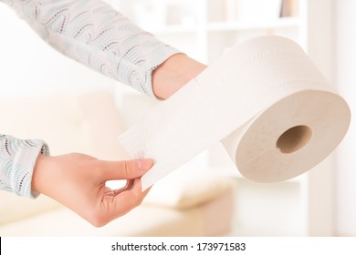 Hand Holding Toilet Paper At Home