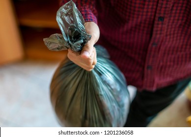 Hand Holding A Trash Garbage Bag At Home To Take It Away