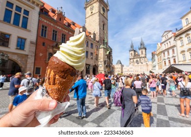 Hand Holding A Trdelnik A Kind Of Spit Cake, Old Town Square On The Background,  Prague, Czech Republic