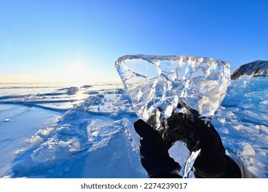 Hand Holding Triangular Ice Formation at Lake Baikal During Winter