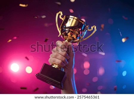 Hand holding a Trophy - Achievement and Victory