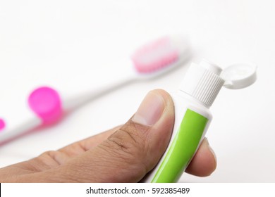 Hand Holding Tube Of Toothpaste On White Background 