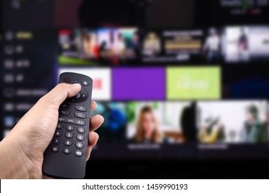 Hand holding tv remote control with Smart TV