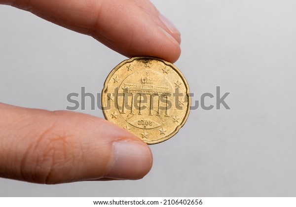 Hand holding twenty euro cents on a white\
background close-up.
