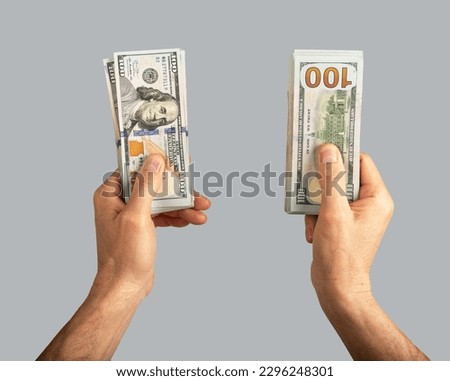 Hand holding two banknotes stacks, dollar money concept.