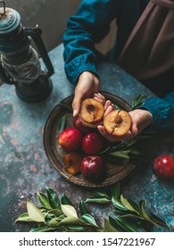 Hand Holding Two Pieces Of Cutting Peach Fruit. A Plate On Table With Raw Peach Fruits, Also Food Decoration In The Table. Food Conceptual Photo