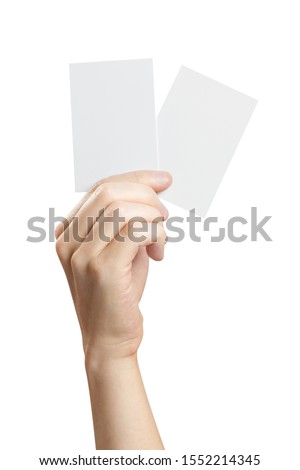 Hand holding two small pieces of paper or plastic (cards, tickets, flyers, invitations, coupons, banknotes, etc.), isolated on white background