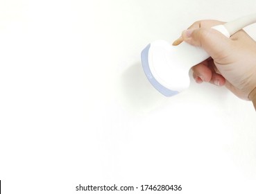 A Hand Holding An Ultrasound Probe On White Background.