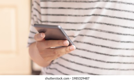 Hand holding and using smartphone.