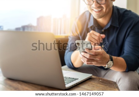 hand holding using texting cell phone and typing computer.businessman at workplace Thinking investment plan.chatting contact Investor.searching for information use internet.connecting people concept
