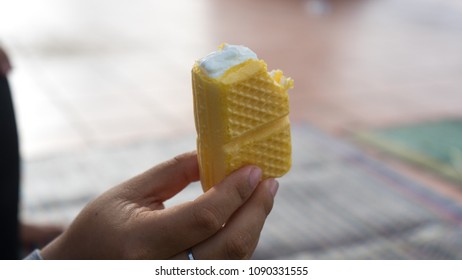 Hand Holding A Vanilla Ice Cream Sandwich.