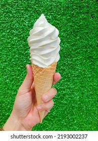 hand holding vanilla ice cream on synthetic grass background - Shutterstock ID 2193002237