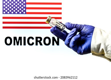 Hand Holding Vial With Covid Vaccine. United States Flag And Omicron Covid Variant Word Written In The Background