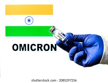 Hand Holding Vial With Covid Vaccine. Indian Flag And Omicron Covid Variant Word Written In The Background