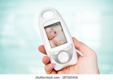 Hand Holding Video Baby Monitor For Security Of The Baby 